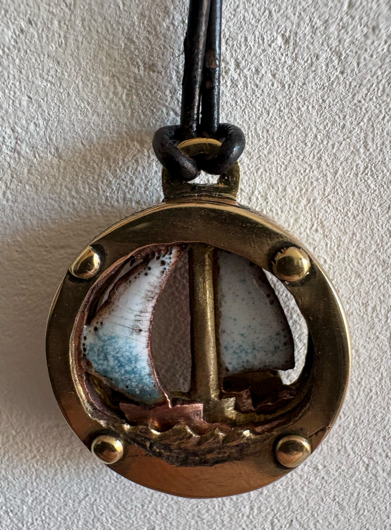 Front view of the brass sailboat pendant